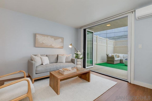 living room featuring a wall mounted air conditioner, hardwood / wood-style floors, and floor to ceiling windows