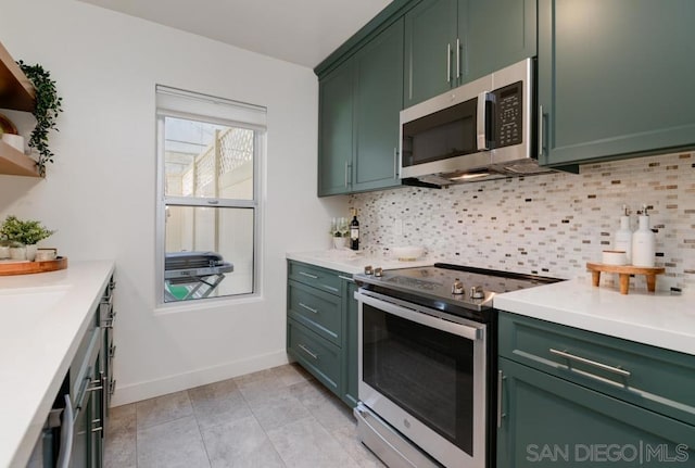 kitchen with green cabinetry, appliances with stainless steel finishes, decorative backsplash, and light tile patterned floors