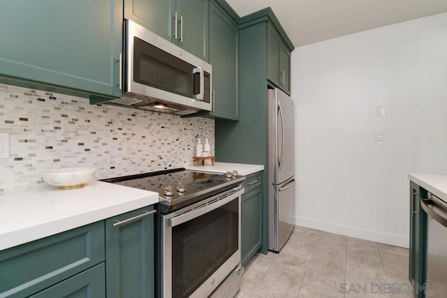 kitchen with decorative backsplash, stainless steel appliances, green cabinetry, and light tile patterned flooring