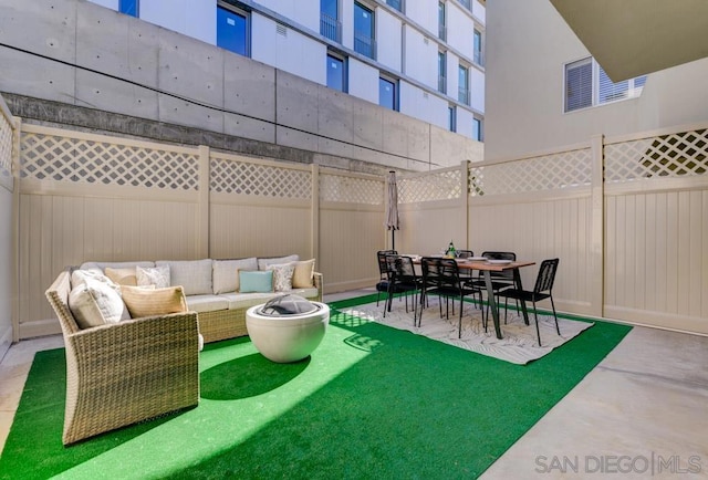 view of patio with an outdoor living space with a fire pit