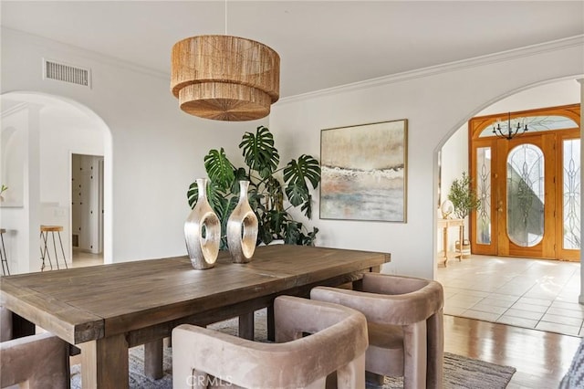 dining space featuring crown molding and light wood-type flooring