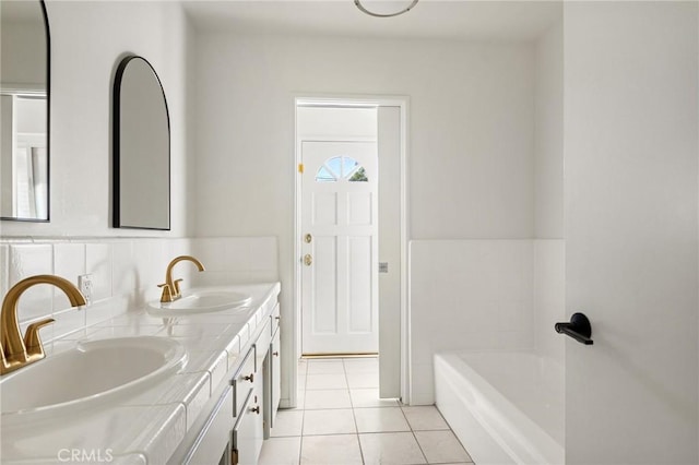 bathroom with tile patterned flooring, vanity, and a tub