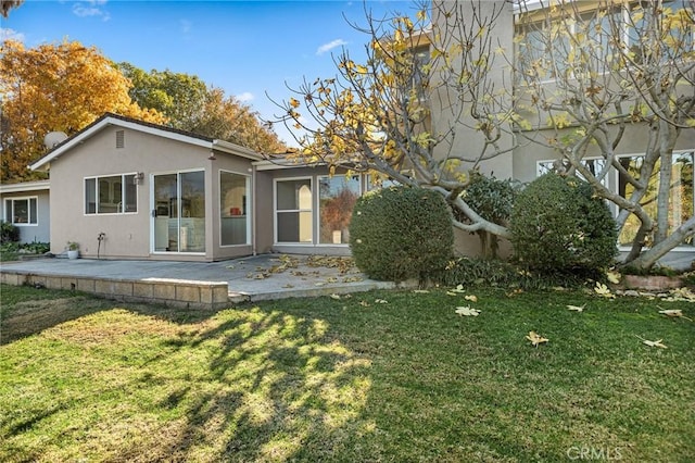 rear view of house with a yard and a patio area