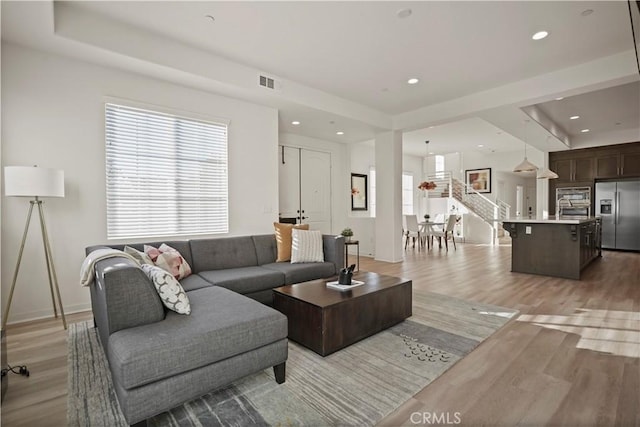 living room with sink and light wood-type flooring