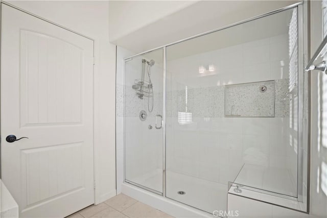 bathroom featuring a shower with door and tile patterned flooring