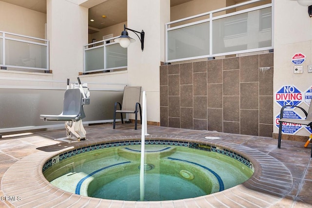 view of swimming pool with an indoor hot tub and a patio