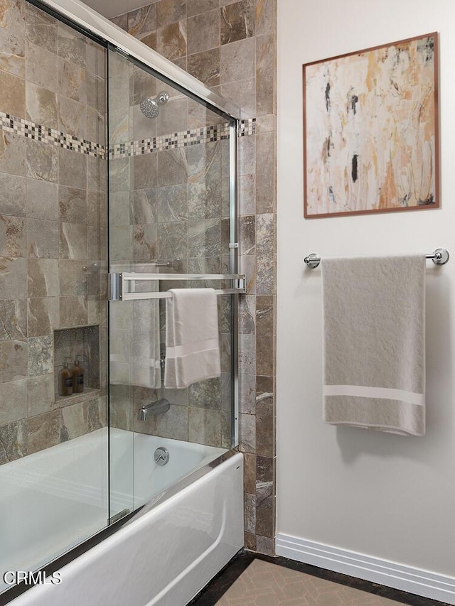 bathroom featuring combined bath / shower with glass door