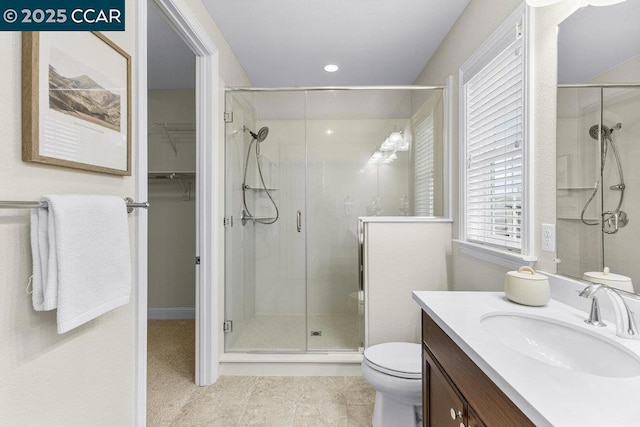 bathroom with vanity, toilet, and a shower with shower door