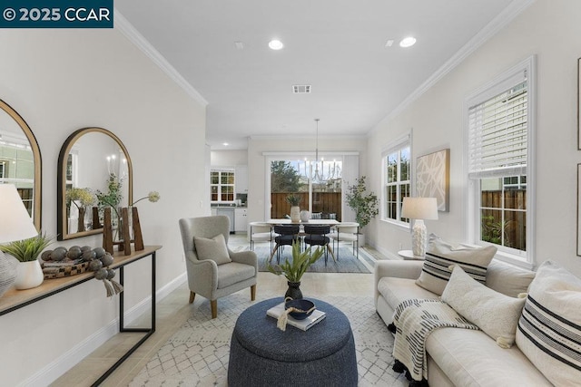 living room with an inviting chandelier and ornamental molding