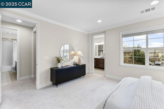 bedroom with ornamental molding, connected bathroom, and light carpet