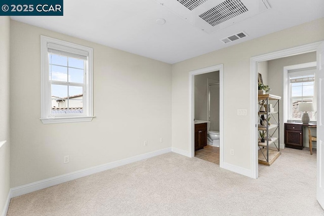 unfurnished bedroom with light colored carpet and ensuite bath