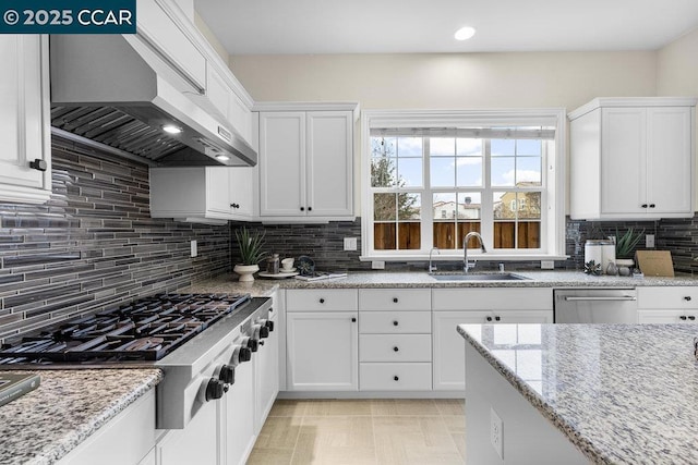 kitchen with wall chimney range hood, stainless steel appliances, and white cabinets