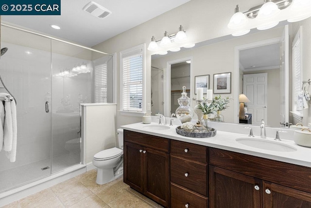 bathroom featuring a shower with door, vanity, tile patterned floors, and toilet