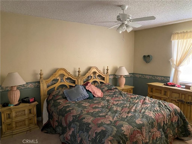 bedroom with ceiling fan, a textured ceiling, and carpet