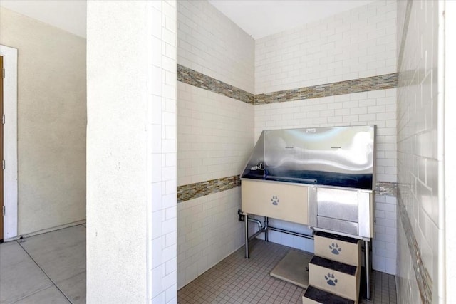 miscellaneous room featuring tile walls and light tile patterned floors