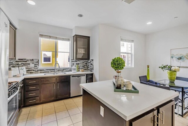 kitchen featuring appliances with stainless steel finishes, sink, a wealth of natural light, and dark brown cabinets