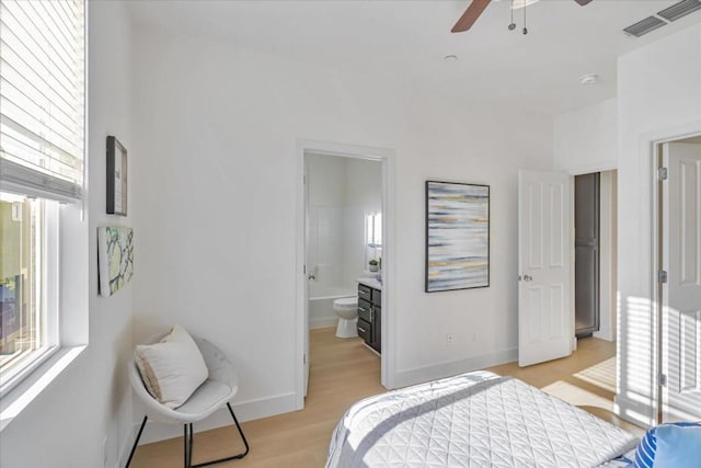 bedroom with connected bathroom, ceiling fan, and light wood-type flooring