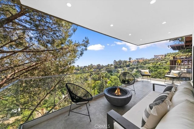 balcony with an outdoor living space with a fire pit