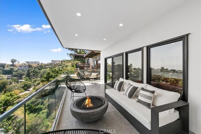 balcony featuring an outdoor living space with a fire pit