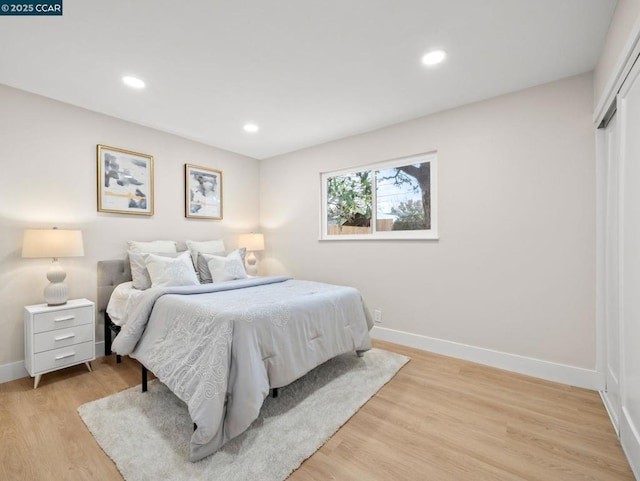 bedroom with light hardwood / wood-style floors and a closet