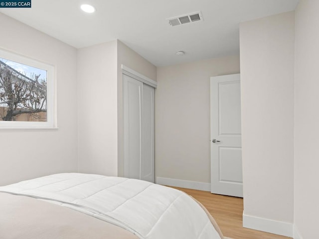 bedroom featuring light hardwood / wood-style floors and a closet