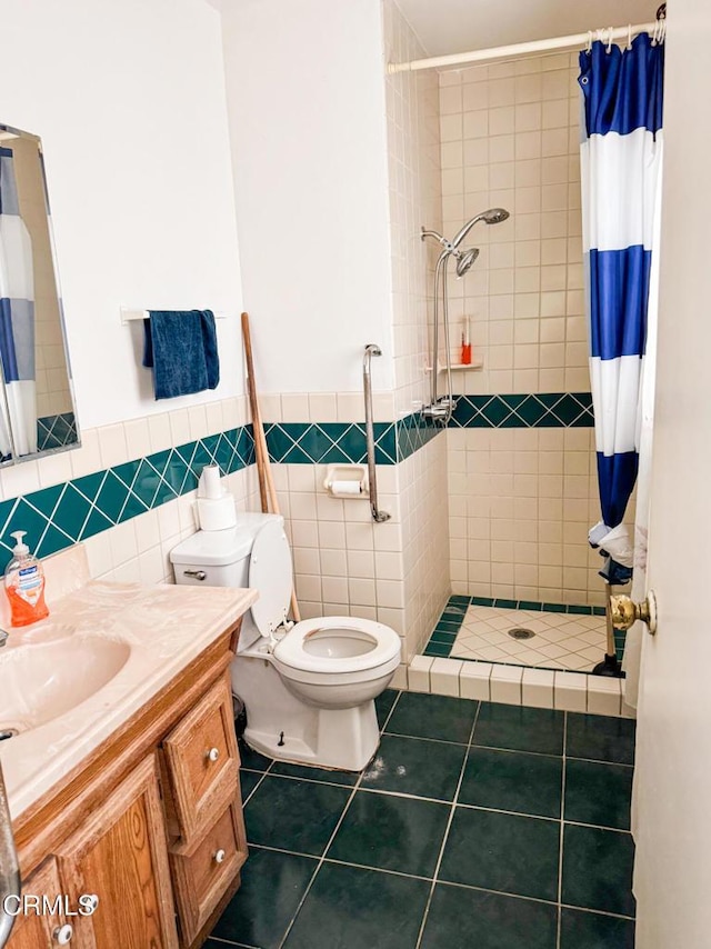 bathroom featuring tile patterned floors, toilet, tile walls, vanity, and curtained shower