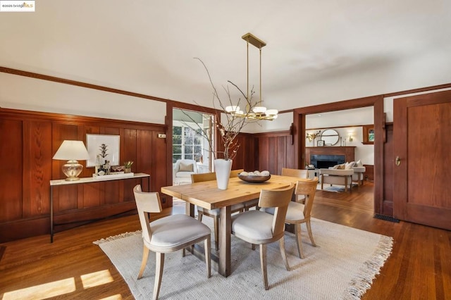 dining space featuring dark wood-type flooring and an inviting chandelier