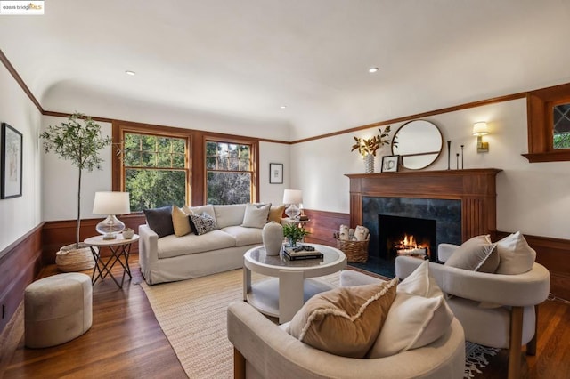 living room with hardwood / wood-style flooring, wooden walls, and a fireplace