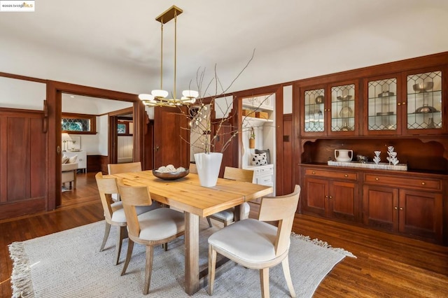 dining room with a notable chandelier and dark wood-type flooring