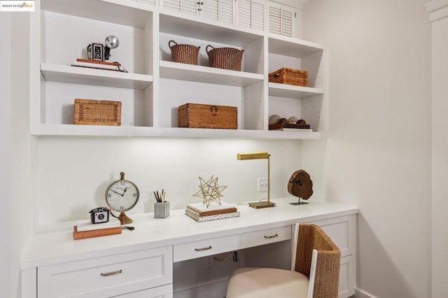 bar featuring white cabinetry and built in desk