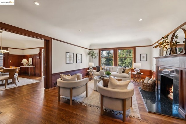 living room with ornamental molding, a high end fireplace, and dark hardwood / wood-style flooring