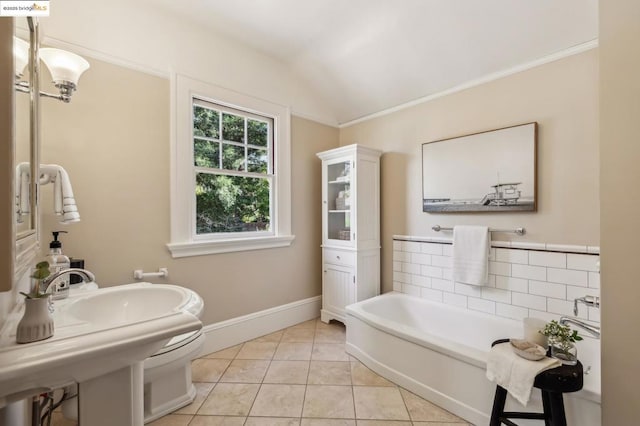 bathroom with vaulted ceiling, a bath, tile patterned flooring, and crown molding