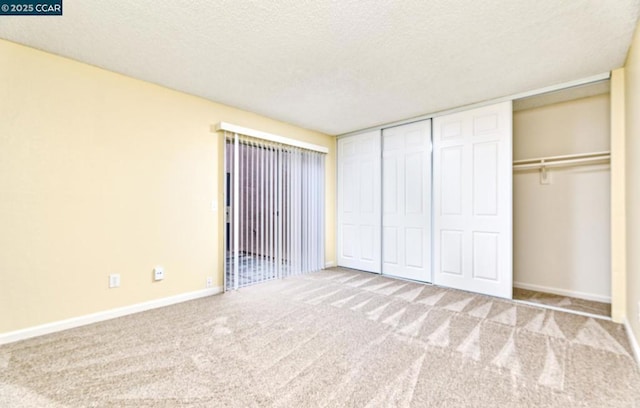 unfurnished bedroom featuring light colored carpet, a closet, and a textured ceiling