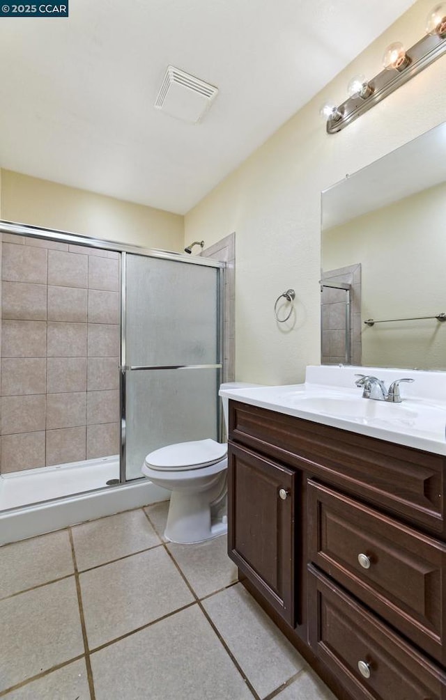 bathroom featuring tile patterned floors, vanity, toilet, and an enclosed shower