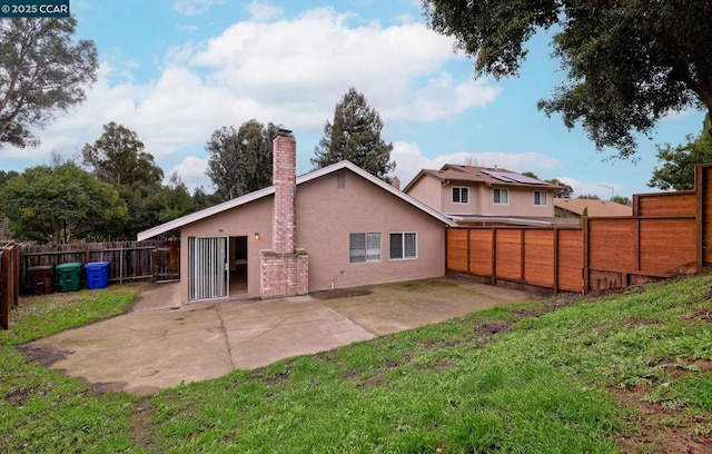 rear view of property featuring a lawn and a patio area