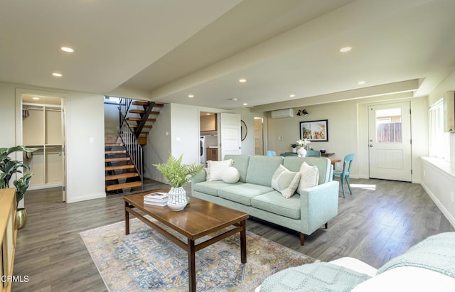 living room with dark hardwood / wood-style floors and a wall unit AC