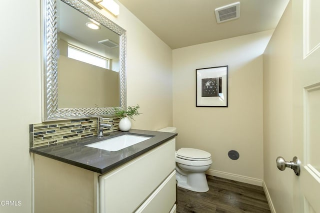 bathroom with vanity, decorative backsplash, toilet, and hardwood / wood-style flooring