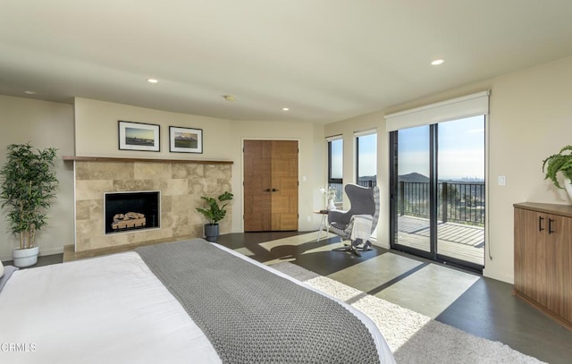 bedroom featuring a tile fireplace and access to outside