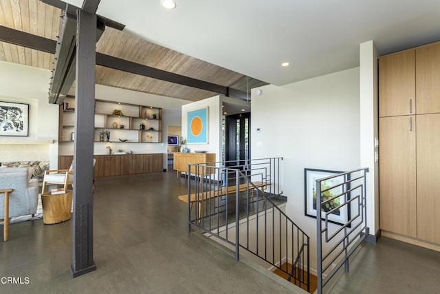 interior space featuring wood ceiling, beam ceiling, and concrete flooring