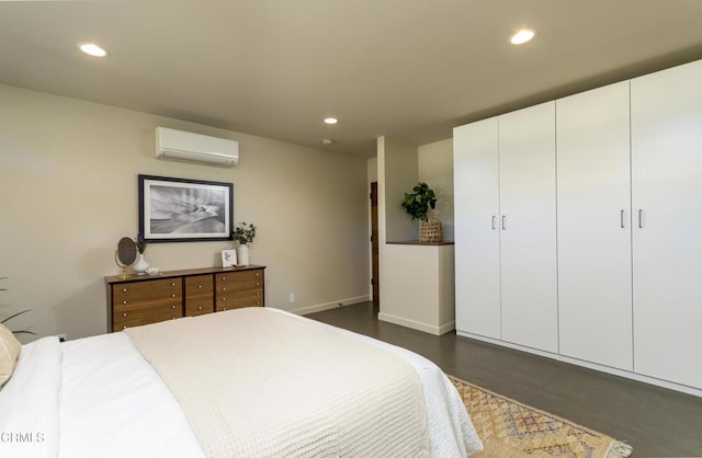 bedroom with dark hardwood / wood-style floors and a wall mounted AC