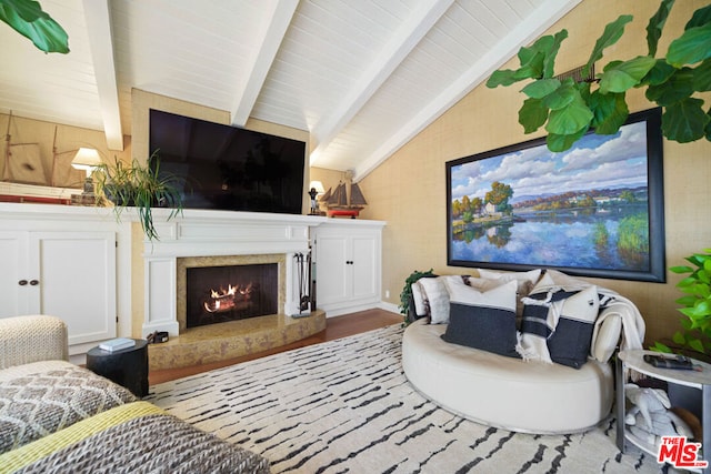 living room featuring hardwood / wood-style floors, lofted ceiling with beams, and a premium fireplace