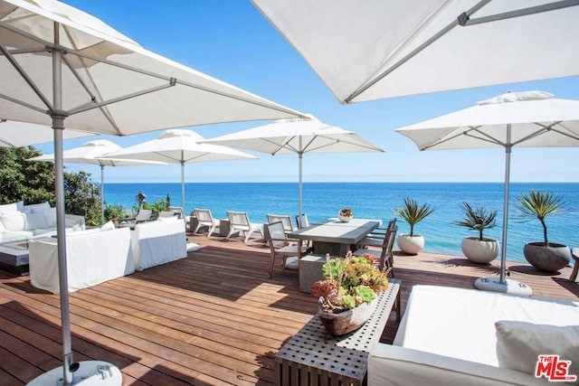 deck featuring an outdoor living space and a water view