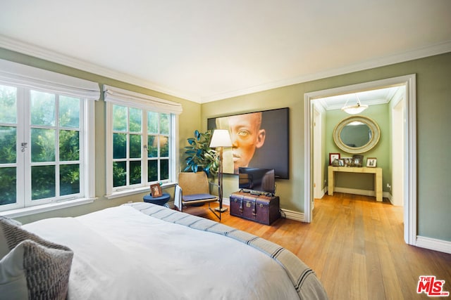 bedroom with ornamental molding and light hardwood / wood-style floors