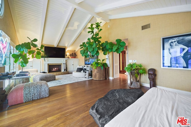 bedroom featuring hardwood / wood-style floors and vaulted ceiling with beams