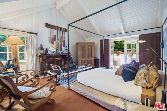 bedroom featuring wood-type flooring and vaulted ceiling with beams