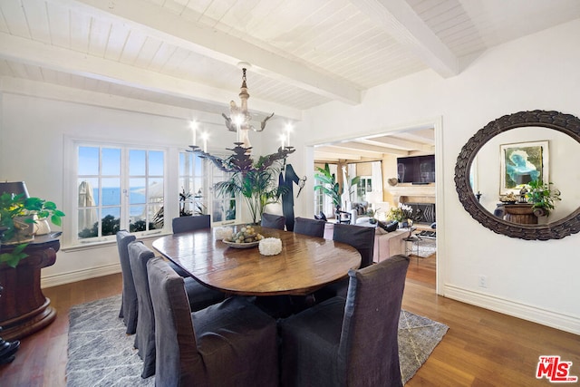 dining space with wood ceiling, dark hardwood / wood-style floors, a water view, a notable chandelier, and beamed ceiling