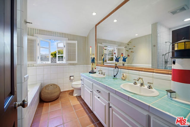 bathroom featuring tile patterned flooring, vanity, tile walls, and toilet