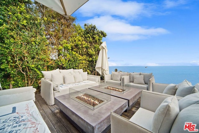 view of patio featuring an outdoor living space with a fire pit and a water view