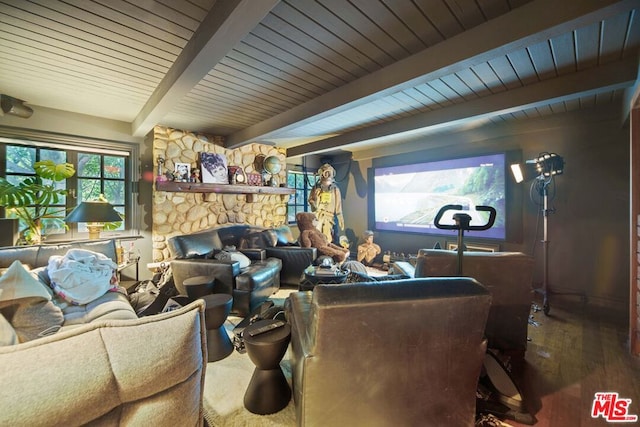 living room with wood-type flooring, a stone fireplace, and beam ceiling