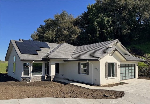 single story home featuring a garage and solar panels